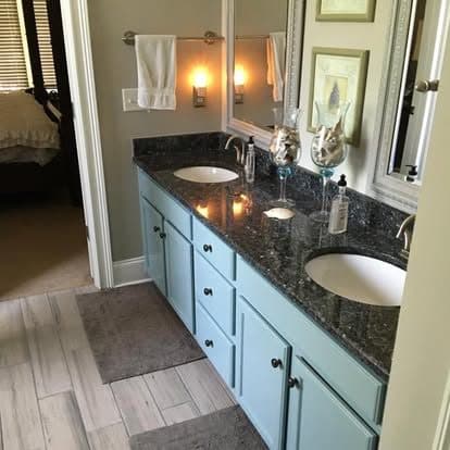 Bathroom remodel with black sink and blue cabinets